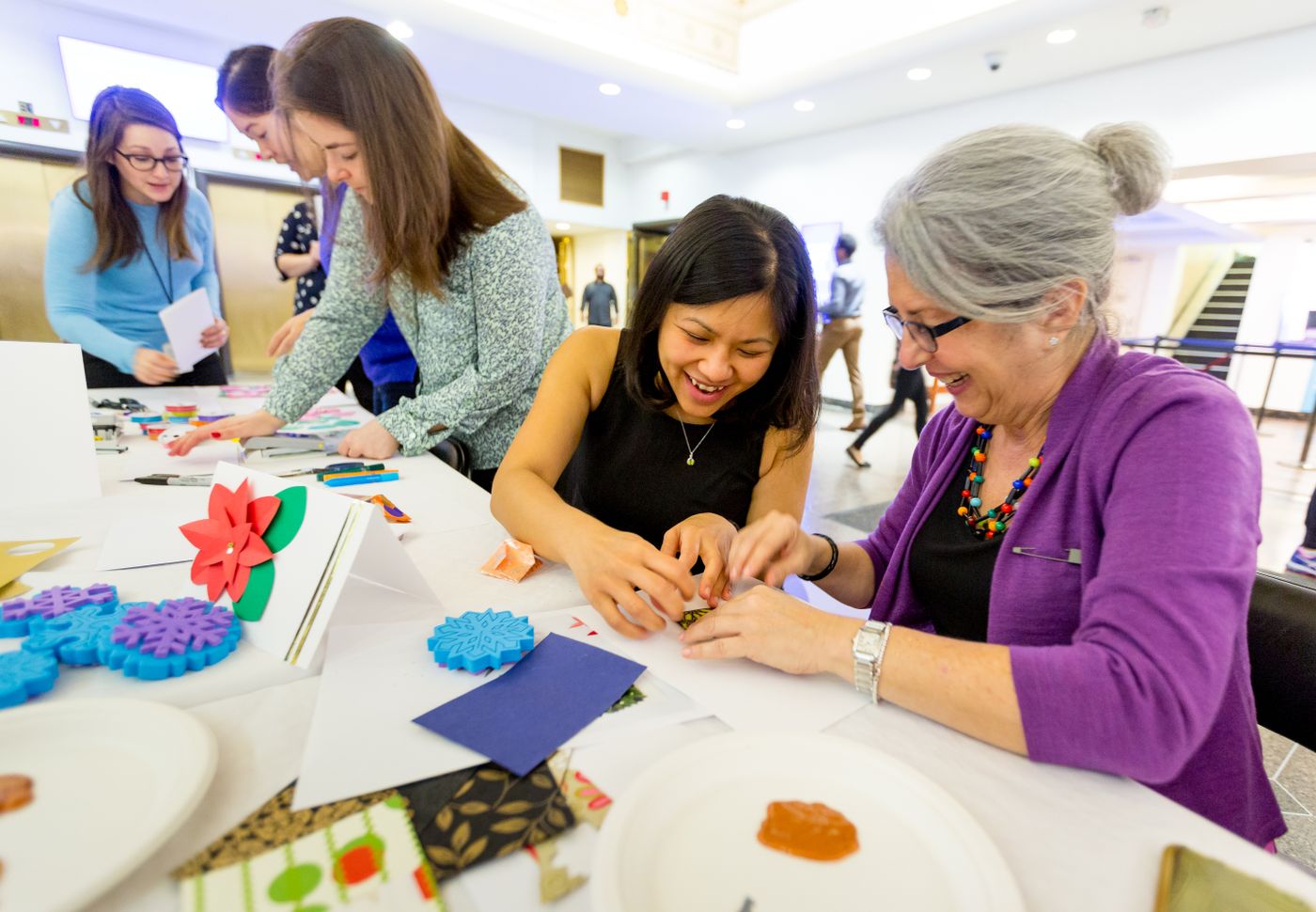 Des femmes de plusieurs générations créent ensemble autour d’une table d’atelier