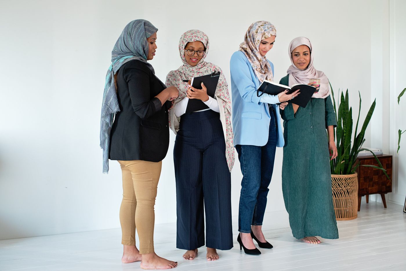 Quatre femmes réunies autour de leurs carnets, partageant leurs idées